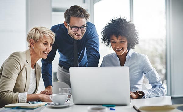 Team of colleagues in front of a laptop